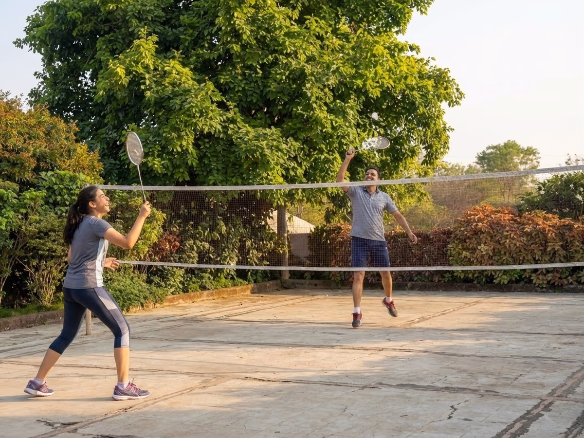 Father and daughter playing badminton on the resort lawn