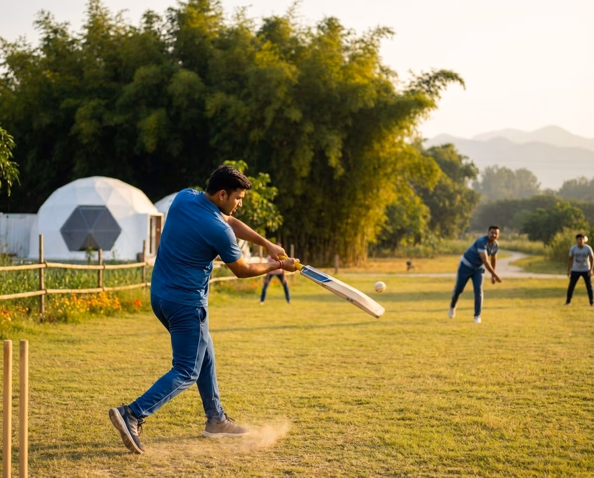 Young man batting mid-swing on the resort cricket lawn at golden hour