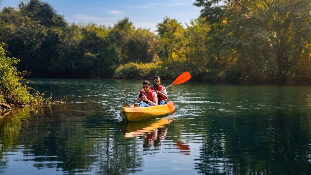 Couple kayaking on the calm Pavana river surrounded by lush green banks