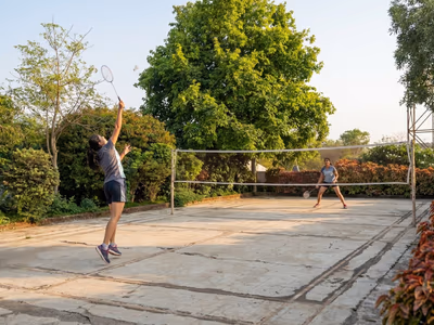 Guests playing badminton on outdoor court at The Glen Woods Resort