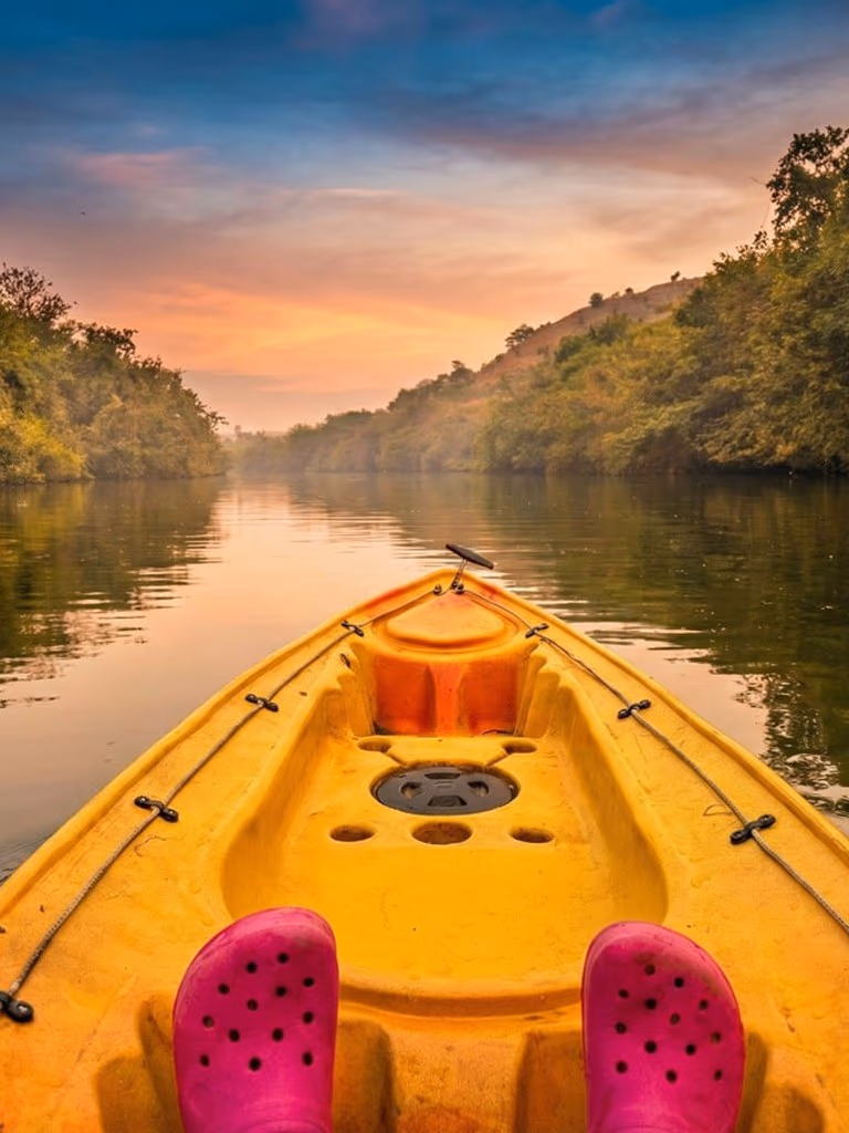 Couple kayaking on the calm Pavana river with lush green banks at The Glen Woods Resort